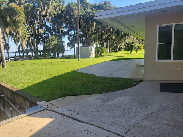 view of yard with a storage shed and a patio area