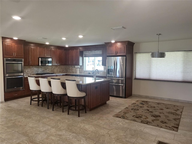 kitchen with sink, backsplash, hanging light fixtures, a center island, and stainless steel appliances