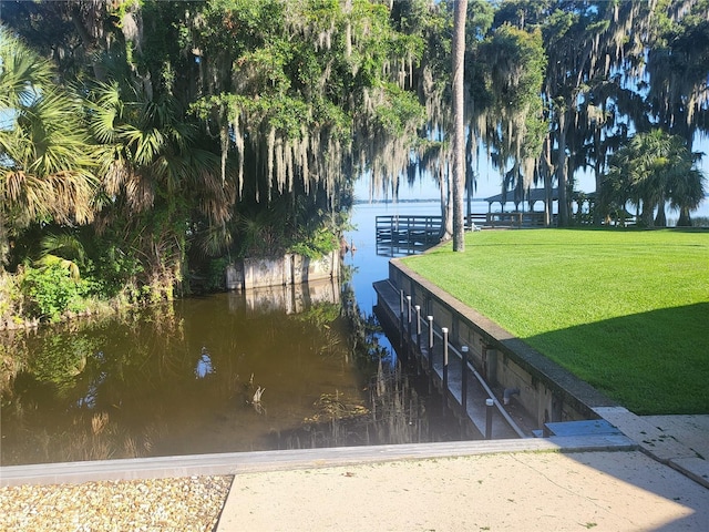 exterior space featuring a lawn and a water view