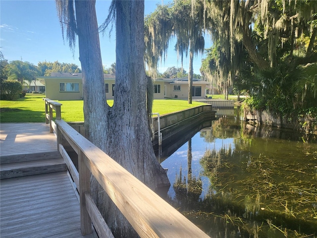 view of dock featuring a yard and a water view