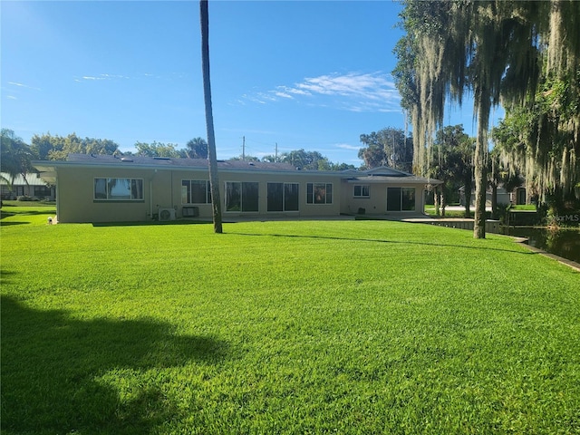 back of property featuring a lawn