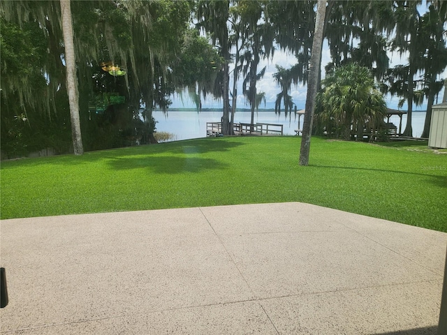 view of community with a patio, a water view, and a lawn