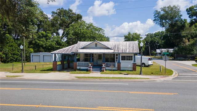 view of front of house featuring a garage, a front lawn, and a porch