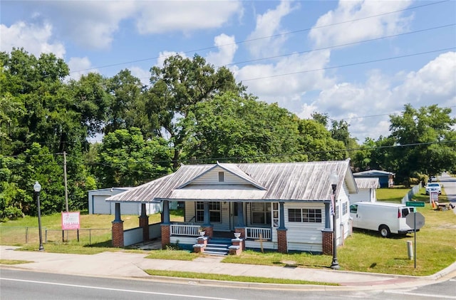 view of front of house with a front yard and covered porch