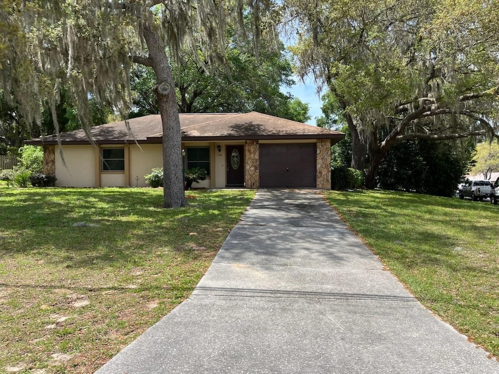 ranch-style house featuring a garage and a front yard