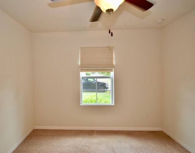 unfurnished room with ceiling fan and carpet