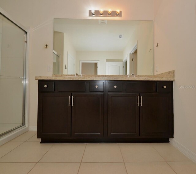 bathroom with walk in shower, tile patterned floors, and vanity