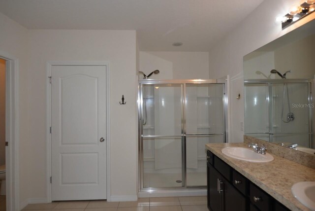 bathroom with vanity, a shower with shower door, and tile patterned floors