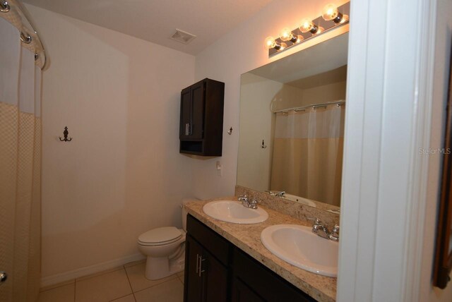 bathroom with a shower with shower curtain, vanity, toilet, and tile patterned flooring