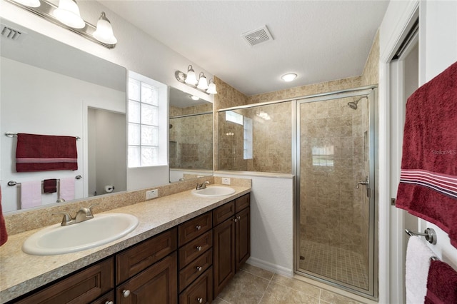 bathroom featuring tile patterned flooring, vanity, and a shower with door