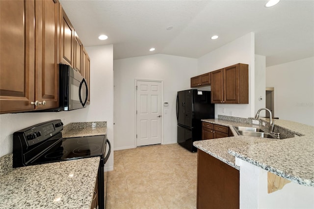 kitchen with kitchen peninsula, light stone countertops, sink, and black appliances