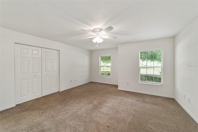 unfurnished bedroom featuring carpet flooring, ceiling fan, and a closet