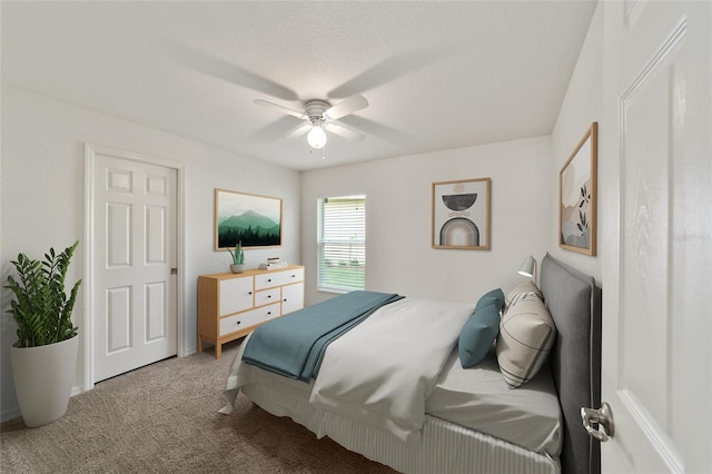 bedroom with carpet, a textured ceiling, and ceiling fan