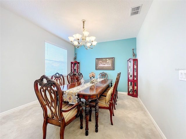 carpeted dining space with a chandelier