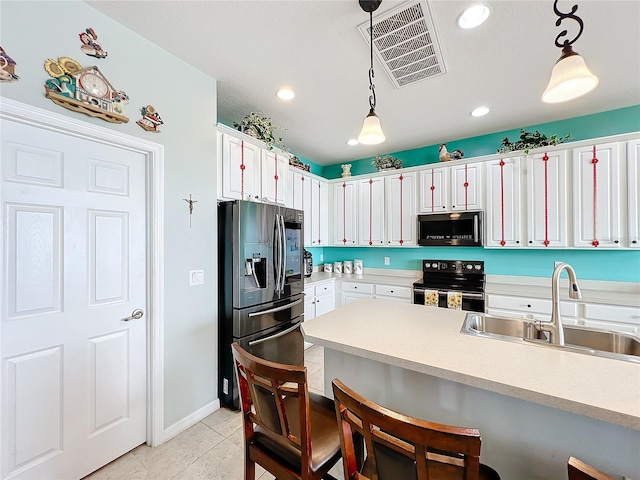 kitchen with sink, range with electric cooktop, stainless steel fridge, and pendant lighting