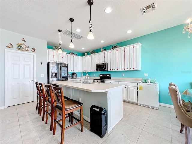 kitchen featuring hanging light fixtures, a kitchen island with sink, white cabinetry, appliances with stainless steel finishes, and sink