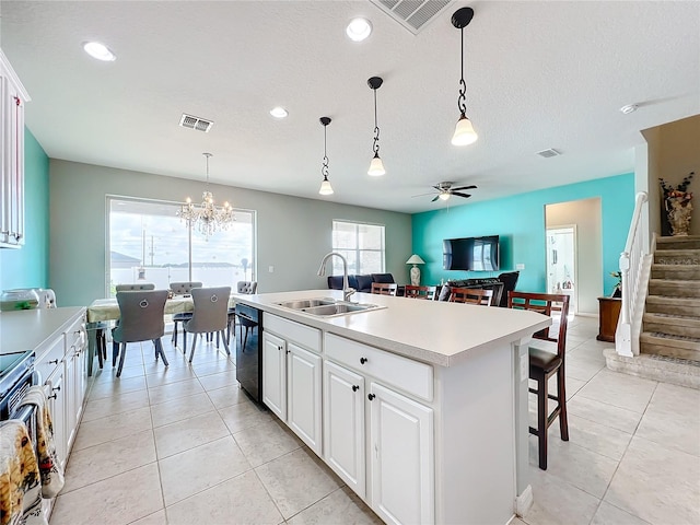 kitchen with white cabinetry, an island with sink, pendant lighting, sink, and black dishwasher