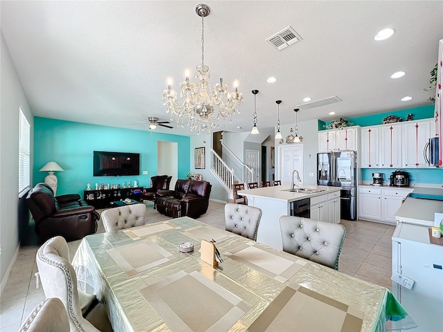 dining space featuring sink, light tile floors, and ceiling fan with notable chandelier