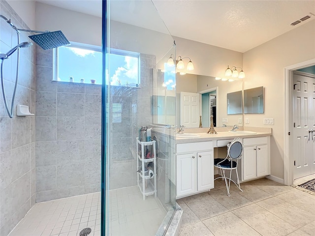 bathroom with a shower with shower door, dual vanity, and tile floors