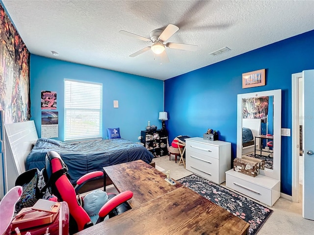 bedroom featuring light colored carpet, ceiling fan, and a textured ceiling