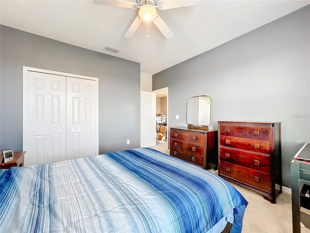 carpeted bedroom featuring a closet and ceiling fan