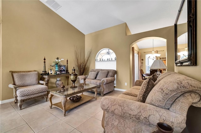 living room featuring an inviting chandelier, lofted ceiling, and light tile patterned flooring