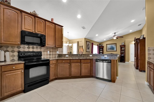 kitchen with black appliances, dark stone countertops, sink, and vaulted ceiling