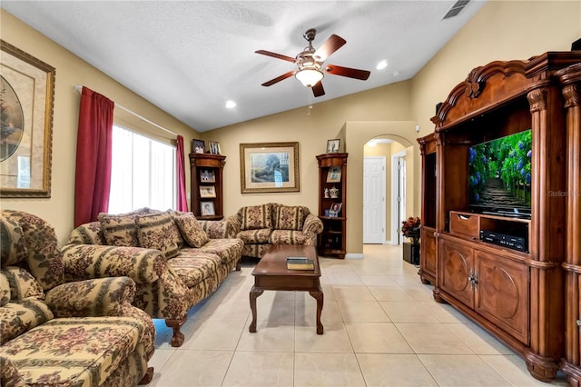 tiled living room featuring ceiling fan, a textured ceiling, and vaulted ceiling