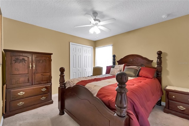 carpeted bedroom featuring a textured ceiling, a closet, and ceiling fan