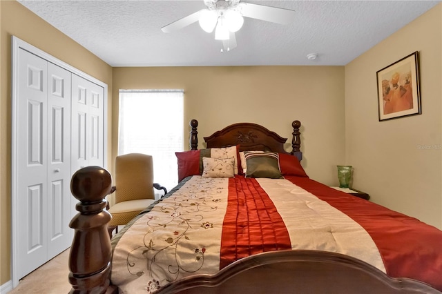 carpeted bedroom with ceiling fan, a closet, and a textured ceiling