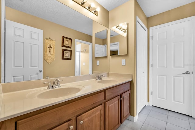 bathroom with tile patterned floors, vanity, and a textured ceiling