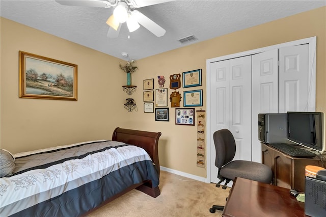 bedroom featuring light carpet, a textured ceiling, a closet, and ceiling fan