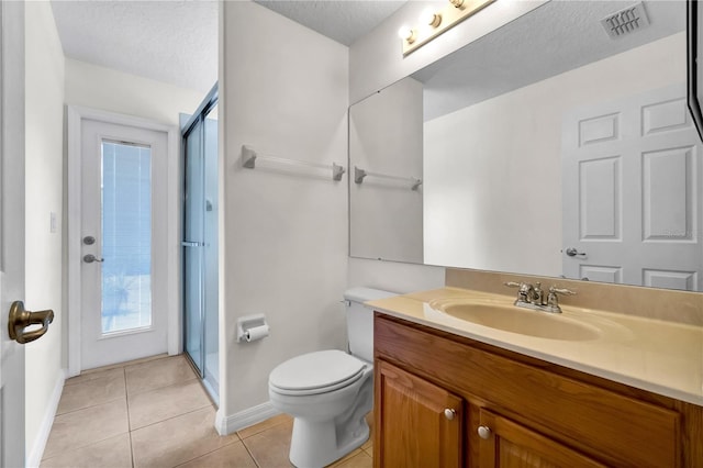 bathroom with tile patterned floors, an enclosed shower, a textured ceiling, toilet, and vanity