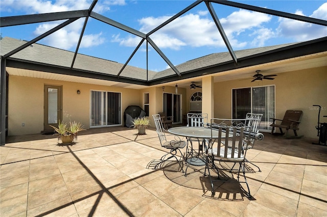 view of patio with glass enclosure, ceiling fan, and a grill