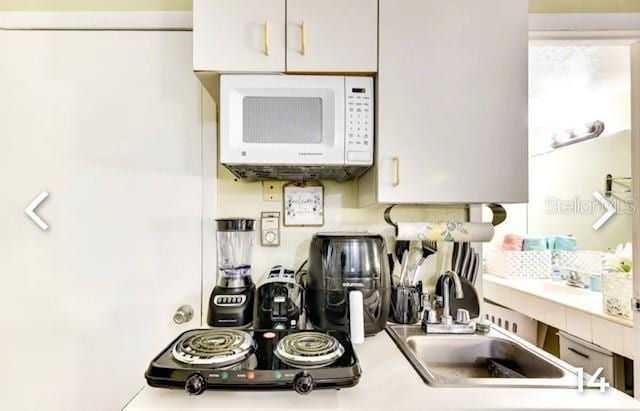 kitchen featuring white cabinetry and sink