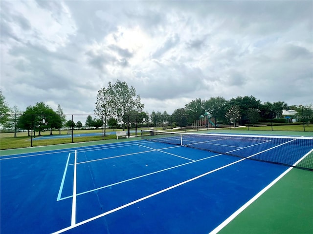 view of tennis court with a playground