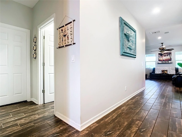 corridor with dark wood-style flooring, recessed lighting, visible vents, and baseboards