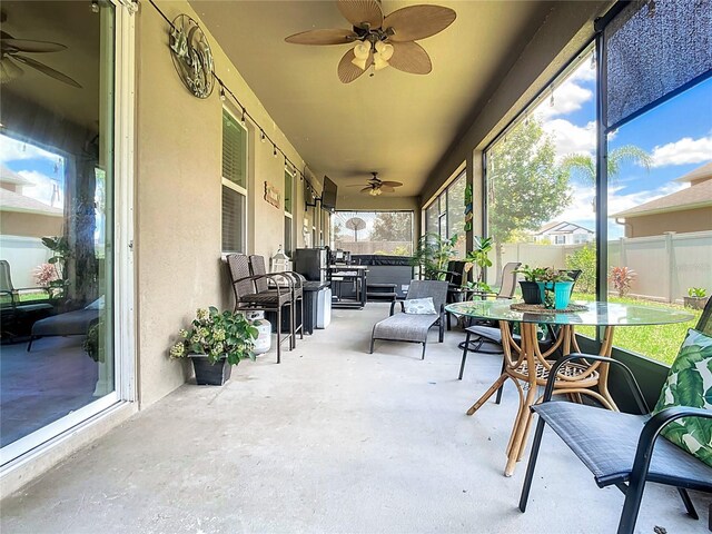 sunroom featuring ceiling fan