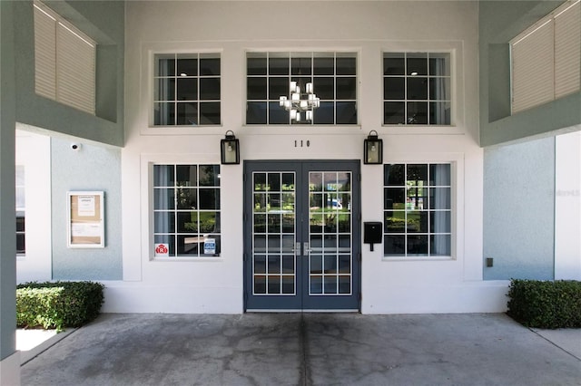 doorway to property featuring french doors and stucco siding