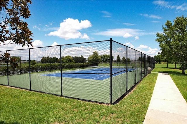 view of tennis court featuring a yard