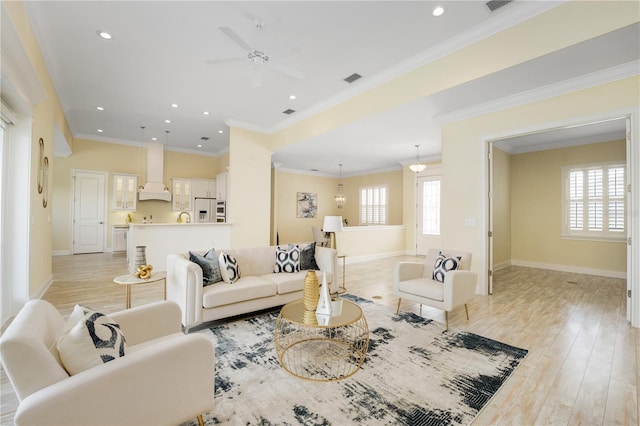 living room featuring crown molding, light hardwood / wood-style flooring, and ceiling fan