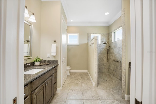 bathroom featuring crown molding, toilet, vanity, and tiled shower