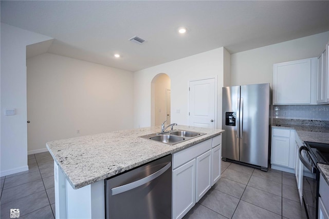 kitchen with white cabinets, sink, light tile patterned floors, an island with sink, and appliances with stainless steel finishes