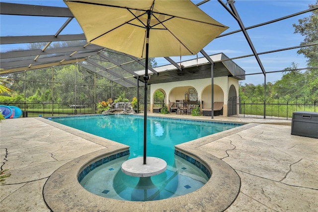 view of swimming pool featuring glass enclosure and a patio