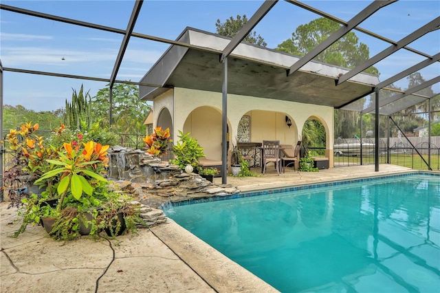 view of swimming pool featuring a patio and glass enclosure