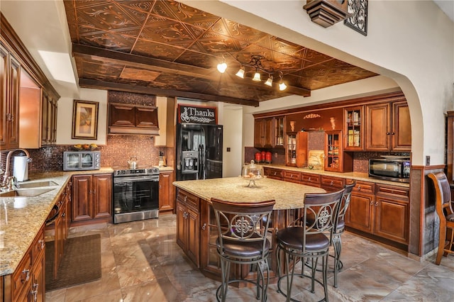 kitchen featuring a center island, sink, decorative backsplash, black appliances, and custom range hood