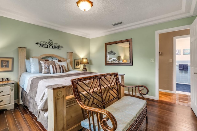 bedroom with a textured ceiling and dark wood-type flooring