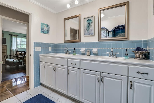 bathroom with tile patterned floors, vanity, ornamental molding, and tile walls