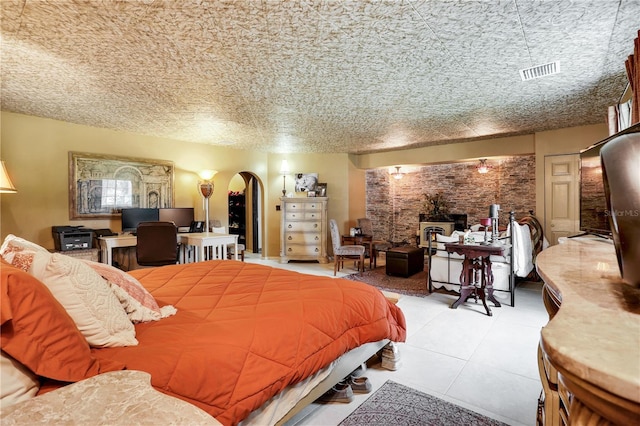 bedroom with a wood stove and light tile patterned floors