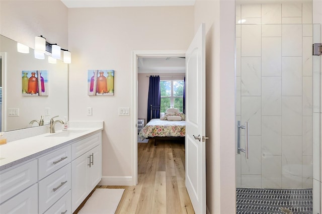 bathroom featuring hardwood / wood-style floors, vanity, and a shower with shower door